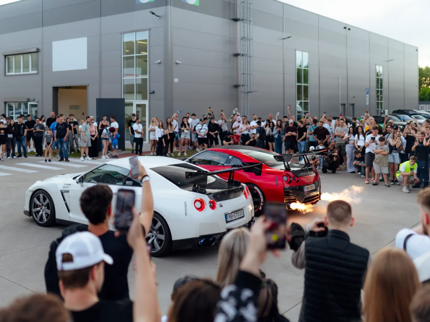 Dve Nissan GT-R s plameňmi z výfuku pred davom fanúšikov na Greta Tour 2026